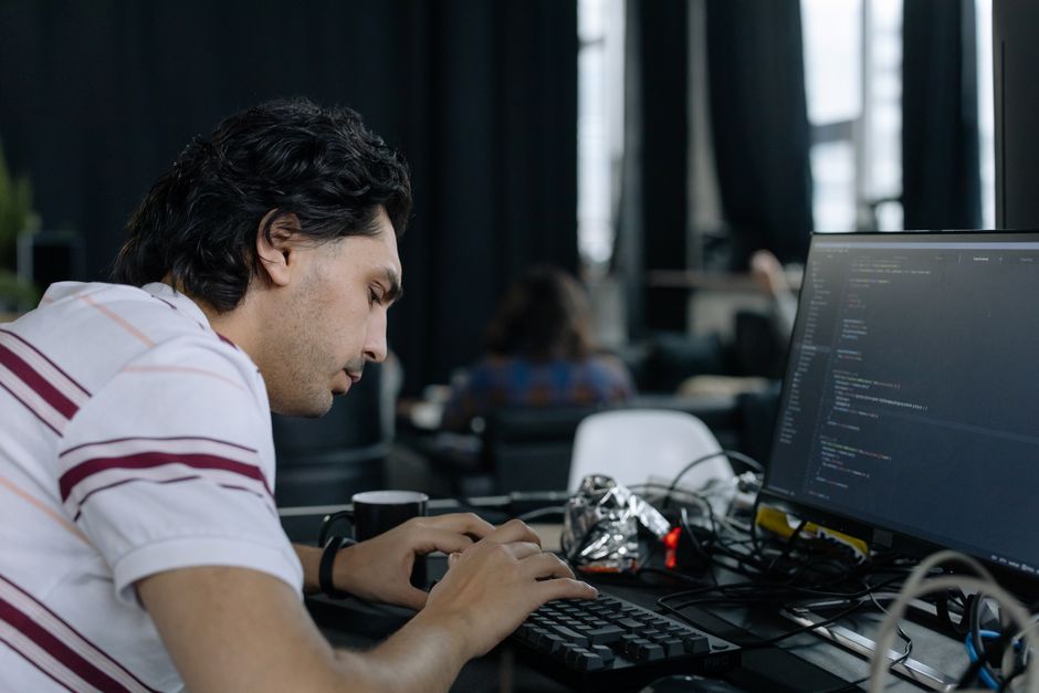 Programer intenzivno tipka na radnoj stanici u suvremenom uredskom prostoru